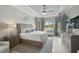 Bright bedroom with a decorative tray ceiling, sitting area, and a large window bringing in lots of natural light at 5656 Cantucci St, Nokomis, FL 34275