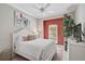 Light and airy bedroom featuring white furniture, a colorful accent wall, and a large window with a view to the outside at 5656 Cantucci St, Nokomis, FL 34275
