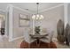 Formal dining room boasts modern chandelier, neutral paint, and stylish decor at 5656 Cantucci St, Nokomis, FL 34275