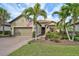 Charming single-story home featuring a paver driveway, attached garage and lush tropical landscaping at 5656 Cantucci St, Nokomis, FL 34275