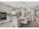 Bright kitchen features white cabinetry, stainless appliances and a large island with bar seating and pendant lighting at 5656 Cantucci St, Nokomis, FL 34275