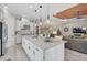 Bright kitchen boasts a large island with bar seating, pendant lighting and an open layout to the living room at 5656 Cantucci St, Nokomis, FL 34275