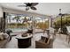 Relaxing lanai with comfortable seating, ceiling fan and serene views of the pool, landscaping and lake at 5656 Cantucci St, Nokomis, FL 34275