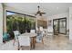 Relaxing lanai with a built-in bar area, dining table, ceiling fan and serene views of the lush landscaping at 5656 Cantucci St, Nokomis, FL 34275