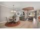 Open-concept dining and living room featuring hardwood floors and lots of natural light at 5656 Cantucci St, Nokomis, FL 34275