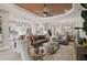 Open-concept living room with modern furnishings, a unique ceiling and seamless flow into the kitchen and dining areas at 5656 Cantucci St, Nokomis, FL 34275