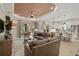 Open-concept living room and kitchen with hardwood floors, ceiling fan, and lots of natural light at 5656 Cantucci St, Nokomis, FL 34275