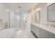 Bright bathroom featuring a soaking tub, walk-in shower, double vanity, and stylish modern fixtures at 5708 Holmes Blvd, Holmes Beach, FL 34217