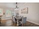 Elegant dining area featuring a modern light fixture, large painting, and wood-look flooring at 5708 Holmes Blvd, Holmes Beach, FL 34217