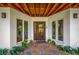 Inviting home entrance featuring a modern wood door and decorative landscaping at 5708 Holmes Blvd, Holmes Beach, FL 34217