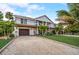 Inviting two-story home featuring a pristine landscaped yard and convenient drive, perfect for coastal living at 5708 Holmes Blvd, Holmes Beach, FL 34217
