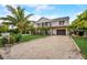Beautiful two-story exterior with balconies, palm trees, and a circular driveway at 5708 Holmes Blvd, Holmes Beach, FL 34217