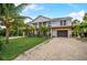 Stunning two-story house featuring double balconies and a gravel driveway at 5708 Holmes Blvd, Holmes Beach, FL 34217