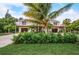 Striking exterior with dual garages, verdant lawns, and charming palm trees at 5708 Holmes Blvd, Holmes Beach, FL 34217