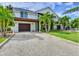Elegant two-story home featuring a lovely yard, balconies, and a driveway at 5708 Holmes Blvd, Holmes Beach, FL 34217