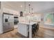 Modern kitchen with stainless steel appliances, an island with bar seating, and wood-look floors at 5708 Holmes Blvd, Holmes Beach, FL 34217
