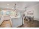 Bright kitchen features an island with pendant lights, white cabinetry, and adjacent dining area at 5708 Holmes Blvd, Holmes Beach, FL 34217