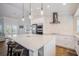 Modern kitchen boasts stainless appliances, an island with bar seating, and white subway tile backsplash at 5708 Holmes Blvd, Holmes Beach, FL 34217