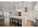Bright, eat-in kitchen with white cabinets, stainless appliances, granite counters, and wood flooring at 5708 Holmes Blvd, Holmes Beach, FL 34217