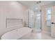 Bright bathroom featuring a glass shower and soaking tub with modern fixtures and a window at 5708 Holmes Blvd, Holmes Beach, FL 34217
