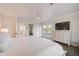 Spacious main bedroom with an en-suite bathroom, TV, private balcony, and white decor at 5708 Holmes Blvd, Holmes Beach, FL 34217