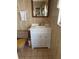 Clean bathroom with a modern vanity, tile flooring, and a toilet with a wood seat cover at 618 51St W Ave, Bradenton, FL 34207