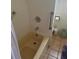 Functional bathroom with a tub and a hand-held shower, neutral tile flooring, and a sink with cabinet at 618 51St W Ave, Bradenton, FL 34207