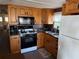 Functional kitchen with wood cabinets, a gas stove, and modern appliances for convenient cooking at 618 51St W Ave, Bradenton, FL 34207