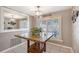 Charming dining nook featuring a stone-topped table, a decorative pendant light, and bright shuttered window views at 6684 Easton Dr, Sarasota, FL 34238