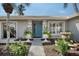 Charming home featuring a vibrant blue front door flanked by decorative planters and a stone fountain at 6684 Easton Dr, Sarasota, FL 34238