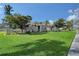 Well maintained home with a beautiful green lawn, decorative entryway, and mature trees under a blue sky at 6684 Easton Dr, Sarasota, FL 34238