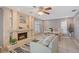 Cozy living room with a stone fireplace, ceiling fan, and dining area with a round white table and shuttered windows at 6684 Easton Dr, Sarasota, FL 34238
