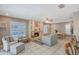 Bright living room featuring a stone fireplace, tile floors, and an adjacent outdoor pool view through shuttered windows at 6684 Easton Dr, Sarasota, FL 34238