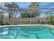 Sparkling pool enclosed by a screen enclosure, surrounded by lush landscaping for privacy and relaxation at 6684 Easton Dr, Sarasota, FL 34238