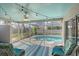 A screened in patio and pool area with an overhead ceiling fan and outdoor furniture at 6684 Easton Dr, Sarasota, FL 34238