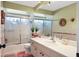 Well-lit bathroom showcasing a vanity with ample counter space and a shower with decorative glass door at 6900 Country Lakes Cir, Sarasota, FL 34243