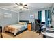 Cozy bedroom featuring a comfortable bed, ceiling fan, and plenty of desk space for work or study at 6900 Country Lakes Cir, Sarasota, FL 34243
