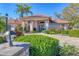 Beautiful home exterior with lush landscaping, stone pathway, and a terracotta tile roof at 6900 Country Lakes Cir, Sarasota, FL 34243