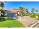 Charming single-story home featuring a paver driveway, lush green lawn, mature landscaping, and a two-car garage at 6900 Country Lakes Cir, Sarasota, FL 34243