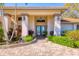 Close up of the home's entrance with stone columns, beautiful landscaping and brick path leading to double doors at 6900 Country Lakes Cir, Sarasota, FL 34243