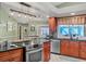 Bright kitchen features stainless appliances, an island cooktop, and views of the dining area and backyard at 6900 Country Lakes Cir, Sarasota, FL 34243