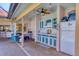 Covered outdoor kitchen with blue and white cabinets, a sink, a grill, and a refrigerator at 6900 Country Lakes Cir, Sarasota, FL 34243