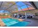Sparkling pool area with a screened enclosure, lounge chairs, and outdoor seating at 6900 Country Lakes Cir, Sarasota, FL 34243