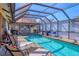 Relaxing pool with a screened enclosure, outdoor kitchen and comfortable lounge chairs at 6900 Country Lakes Cir, Sarasota, FL 34243