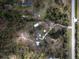 Scenic aerial view of the property displaying the pond, home, and surrounding wooded landscape at 7211 Verna Bethany Rd, Myakka City, FL 34251