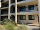 Exterior shot of Hudson Harbour featuring architectural details, black railings, and lush tropical landscaping at 800 Hudson Ave # 102, Sarasota, FL 34236
