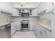 Bright kitchen featuring white cabinets, granite countertops, stainless steel appliances, and a modern backsplash at 800 Hudson Ave # 102, Sarasota, FL 34236