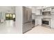 Stainless steel refrigerator overlooking living area and kitchen with white cabinets and modern stainless appliances at 800 Hudson Ave # 102, Sarasota, FL 34236