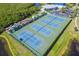 Overhead view of multiple tennis courts surrounded by lush landscaping and nearby recreation areas at 803 Audubon Dr # 803, Bradenton, FL 34209