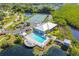 Aerial view of community pool, tennis courts, and recreation center surrounded by lush landscaping at 803 Audubon Dr # 803, Bradenton, FL 34209